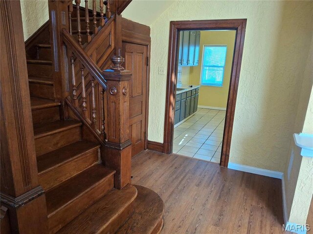 2709 Keokuk St, Saint Louis, MO 63118 - stairs featuring a textured wall, baseboards, and wood finished floors