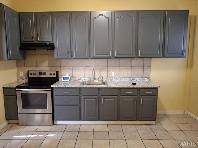 2709 Keokuk St, Saint Louis, MO 63118 - kitchen featuring stainless steel electric stove, under cabinet range hood, gray cabinetry, a sink, and baseboards
