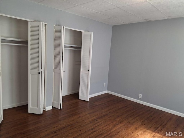 2709 Keokuk St, Saint Louis, MO 63118 - unfurnished bedroom featuring two closets, dark wood finished floors, and baseboards