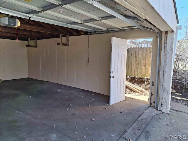 2709 Keokuk St, Saint Louis, MO 63118 - garage featuring a garage door opener, fence, and a carport