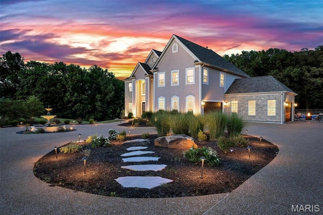 244 US Dr, Wentzville, MO 63385 - view of front of house featuring stone siding, curved driveway, and stucco siding