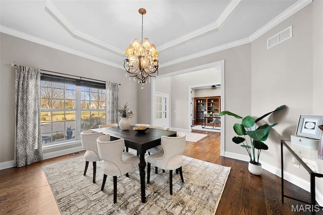244 US Dr, Wentzville, MO 63385 - dining space with a chandelier, a tray ceiling, baseboards, wood finished floors, and crown molding