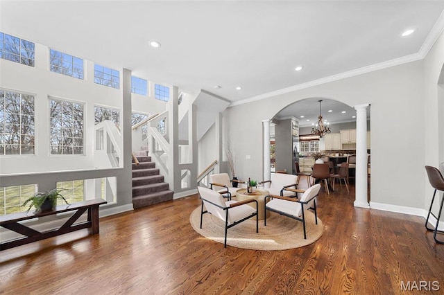 244 US Dr, Wentzville, MO 63385 - living area with ornate columns, dark wood-type flooring, a chandelier, baseboards, and arched walkways