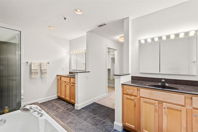 full bath featuring a bath, two vanities, baseboards, recessed lighting, and tile patterned flooring