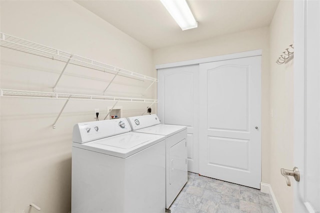 laundry room featuring separate washer and dryer and baseboards
