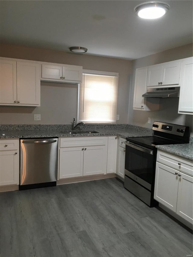 2812 Annapolis Ave, Saint Louis, MO 63114 - kitchen featuring stainless steel appliances, under cabinet range hood, a sink, wood finished floors, and white cabinetry