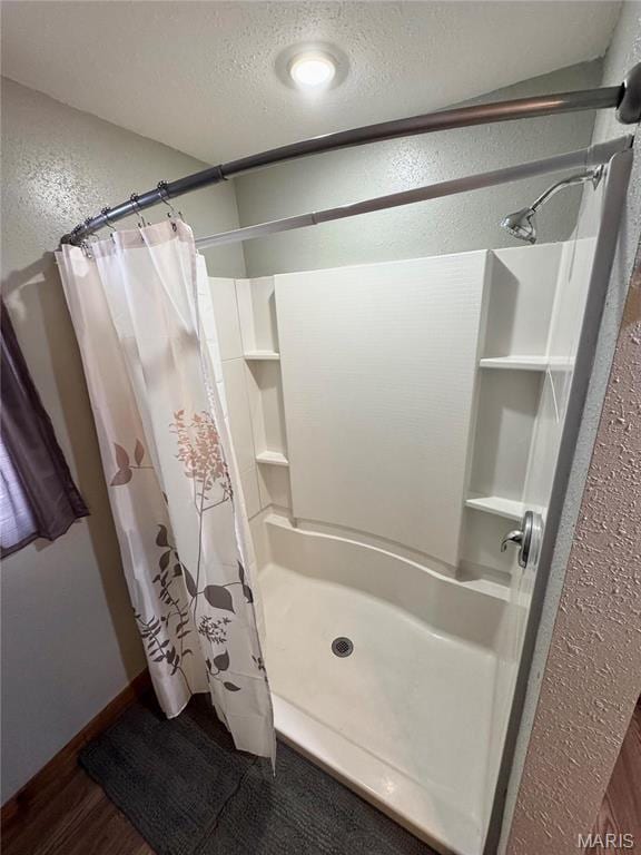 301 W Summer St, Monroe City, MO 63456 - bathroom featuring a shower with curtain, a textured ceiling, a textured wall, and wood finished floors