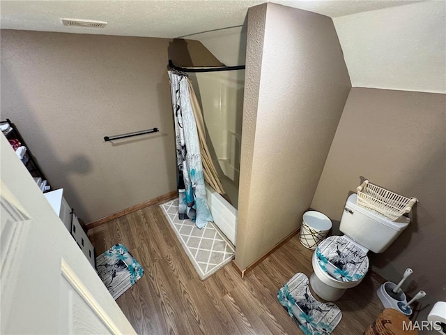 301 W Summer St, Monroe City, MO 63456 - bathroom with toilet, wood finished floors, lofted ceiling, shower / bath combo with shower curtain, and baseboards