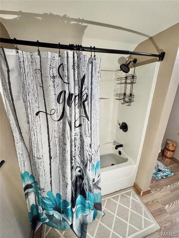 301 W Summer St, Monroe City, MO 63456 - bathroom featuring shower / bath combo with shower curtain, wood finished floors, and baseboards