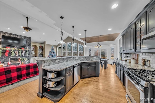 2942 Eagle Pointe Dr, Wentzville, MO 63385 - kitchen with stainless steel appliances, open shelves, lofted ceiling, tasteful backsplash, and light wood-style floors