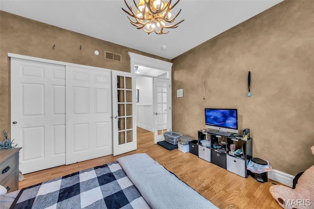 2942 Eagle Pointe Dr, Wentzville, MO 63385 - living room featuring wood finished floors, a chandelier, and french doors