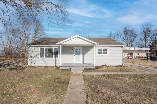 121 W Hicks St, Cardwell, MO 63829 - bungalow-style home featuring covered porch, a carport, a shingled roof, and a front lawn