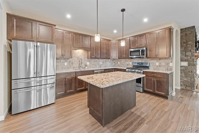 5 Spinney Bough Ct, Wentzville, MO 63385 - kitchen featuring appliances with stainless steel finishes, a sink, decorative backsplash, light stone countertops, and light wood-type flooring