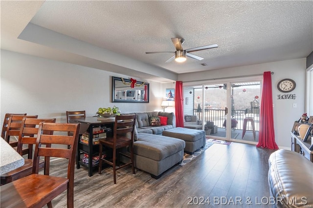 living area with a textured ceiling, a ceiling fan, and wood finished floors