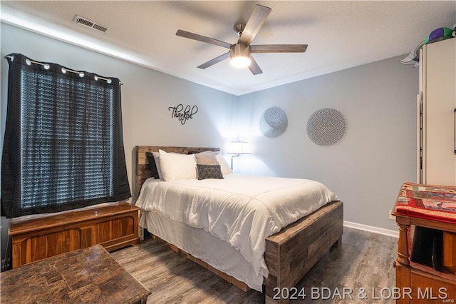 bedroom featuring wood finished floors, ceiling fan, and baseboards