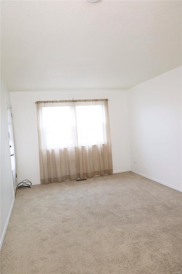 3181 Carefree Ln Unit A, Florissant, MO 63033 - empty room with healthy amount of natural light, light carpet, and baseboards
