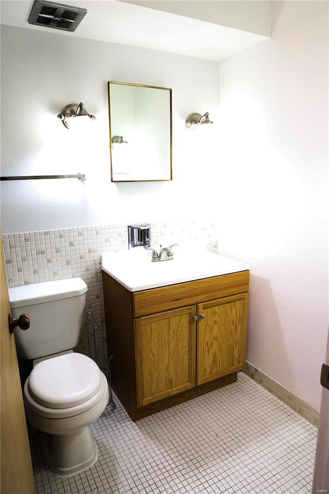 3181 Carefree Ln Unit A, Florissant, MO 63033 - bathroom featuring toilet, vanity, wainscoting, tile walls, and tile patterned floors