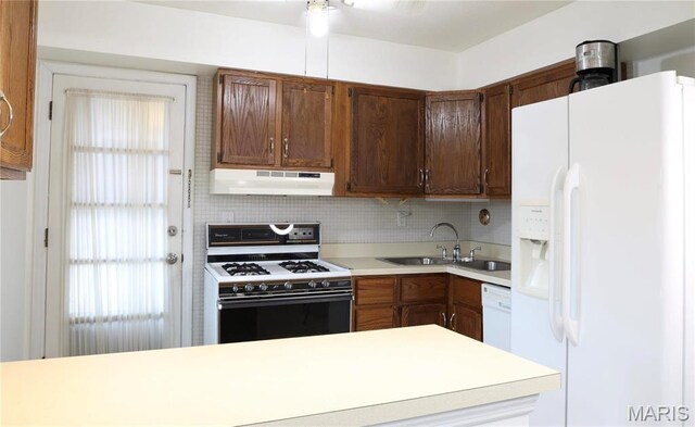 3181 Carefree Ln Unit A, Florissant, MO 63033 - kitchen with white appliances, under cabinet range hood, light countertops, decorative backsplash, and a sink