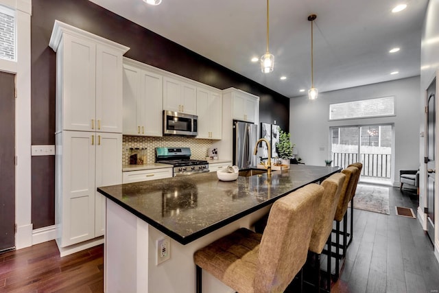 1029 Lami, Saint Louis, MO 63104 - kitchen featuring appliances with stainless steel finishes, dark wood-type flooring, an island with sink, recessed lighting, and backsplash