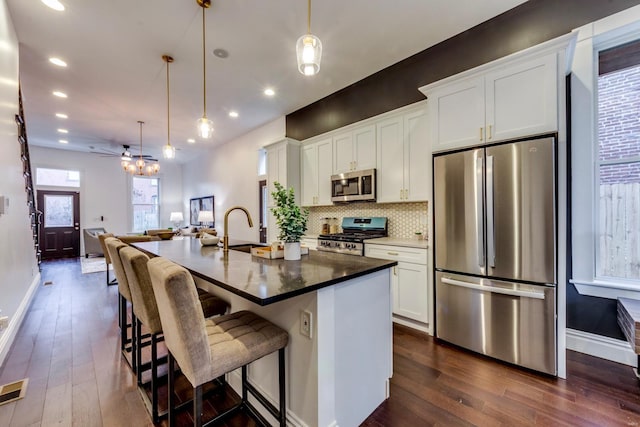 1029 Lami, Saint Louis, MO 63104 - kitchen featuring stainless steel appliances, dark wood-style floors, a sink, a kitchen island with sink, and recessed lighting
