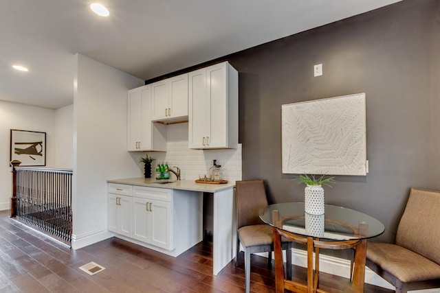 1029 Lami, Saint Louis, MO 63104 - kitchen with a sink, dark wood finished floors, tasteful backsplash, light countertops, and white cabinetry