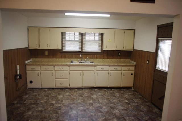 25 N 44th St, Belleville, IL 62226 - kitchen with a sink, a wainscoted wall, wooden walls, plenty of natural light, and cream cabinets