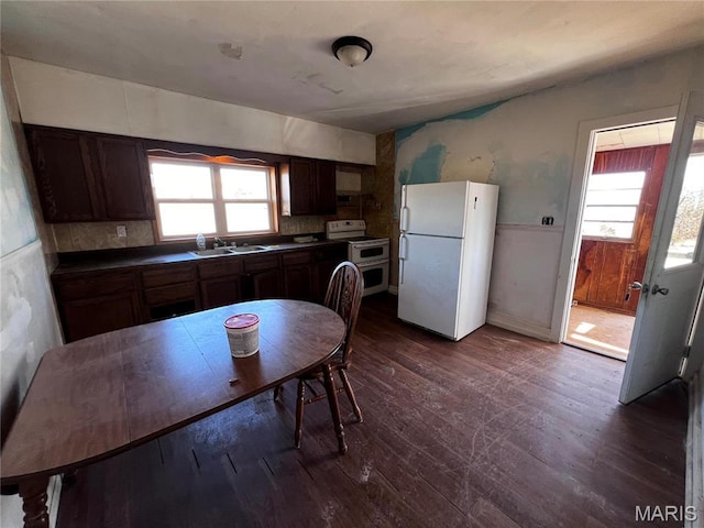 901 Edgemont Blvd, Perryville, MO 63775 - kitchen featuring white appliances, a sink, healthy amount of natural light, dark countertops, and wainscoting