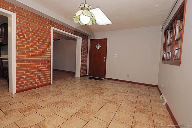 820 Sharon Dr, Cape Girardeau, MO 63701 - spare room with baseboards, brick wall, and light stone finish floors