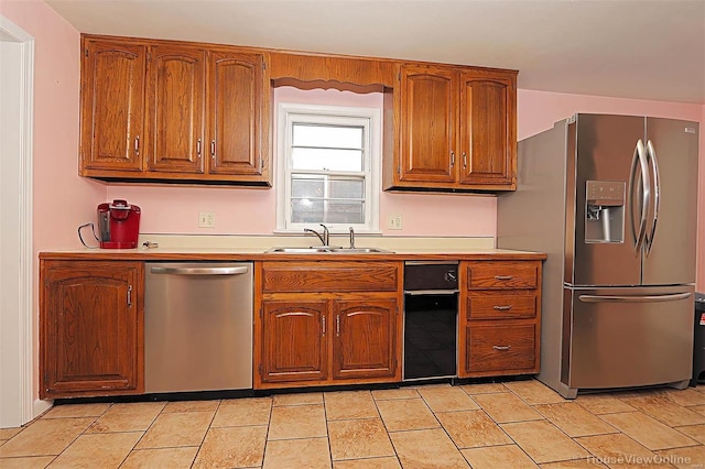 820 Sharon Dr, Cape Girardeau, MO 63701 - kitchen featuring stainless steel appliances, a sink, brown cabinetry, and light countertops