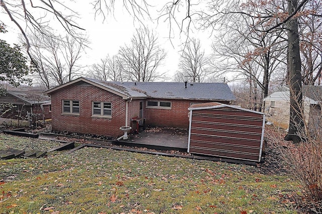 820 Sharon Dr, Cape Girardeau, MO 63701 - back of house featuring a shed, an outdoor structure, a patio, brick siding, and a yard