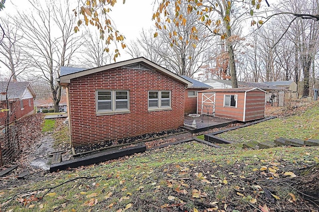 820 Sharon Dr, Cape Girardeau, MO 63701 - back of house with brick siding, an outdoor structure, and a storage unit