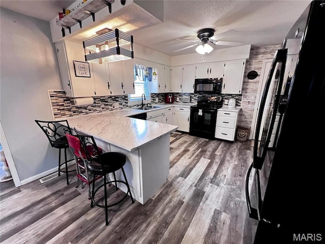 1034 Port Perry Dr, Perryville, MO 63775 - kitchen with black appliances, a peninsula, a sink, decorative backsplash, and ceiling fan