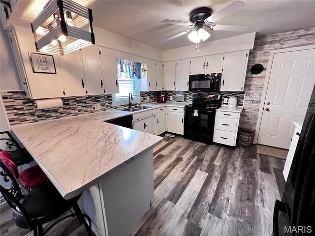 1034 Port Perry Dr, Perryville, MO 63775 - kitchen with black appliances, a sink, ceiling fan, white cabinets, and a peninsula