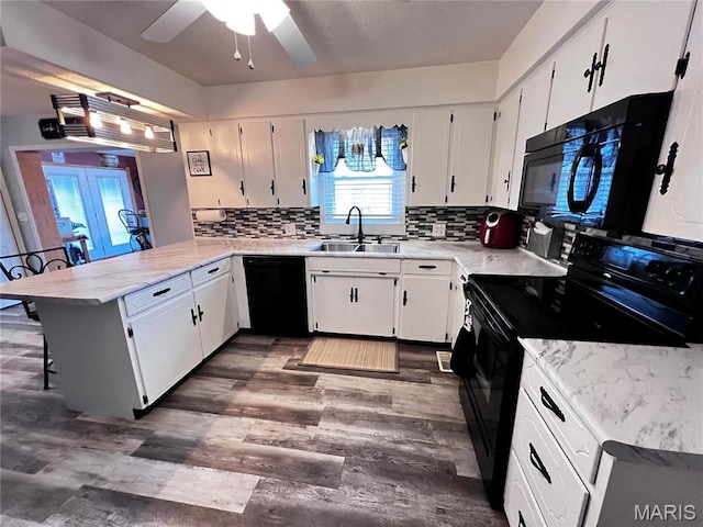 1034 Port Perry Dr, Perryville, MO 63775 - kitchen featuring black appliances, a sink, a peninsula, a ceiling fan, and decorative backsplash
