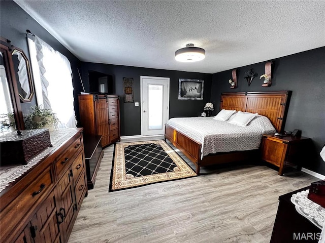 1034 Port Perry Dr, Perryville, MO 63775 - bedroom with multiple windows, a textured ceiling, light wood-type flooring, and baseboards
