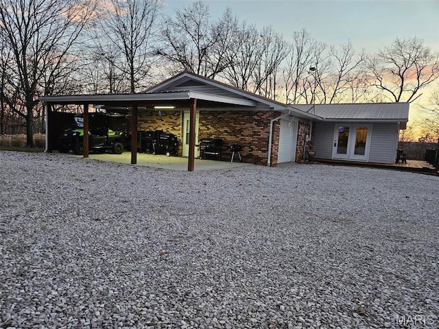 1034 Port Perry Dr, Perryville, MO 63775 - exterior space with driveway, an attached garage, metal roof, a wooden deck, and brick siding