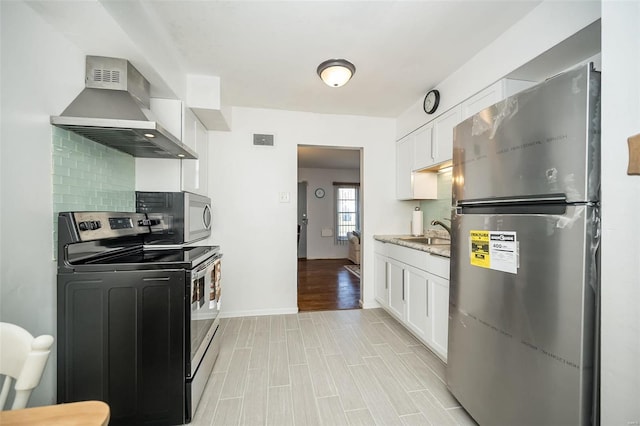 10144 Dellridge Ln, Saint Louis, MO 63136 - kitchen featuring stainless steel appliances, wall chimney exhaust hood, white cabinets, and a sink