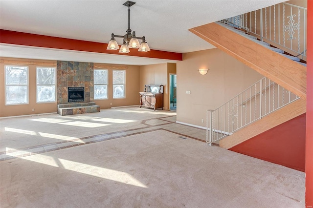 6866 Frandsen Rd, Alhambra, IL 62001 - unfurnished living room with carpet floors, stairs, baseboards, a chandelier, and a stone fireplace
