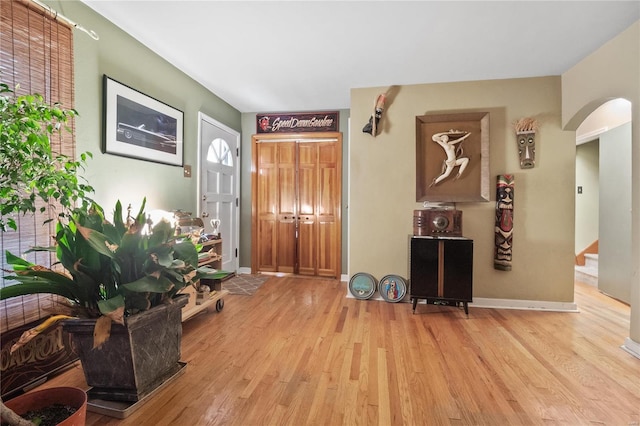 10319 Cable Ave, Frontenac, MO 63131 - foyer entrance with wood finished floors, arched walkways, stairs, and baseboards