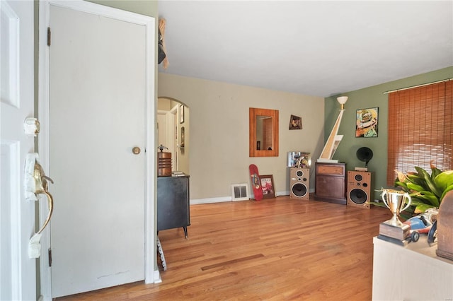 10319 Cable Ave, Frontenac, MO 63131 - interior space with arched walkways, light wood-style flooring, and baseboards
