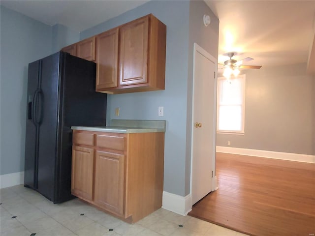 305 Macarthur St, Washington, MO 63090 - kitchen with a ceiling fan, baseboards, black refrigerator with ice dispenser, light countertops, and light wood finished floors