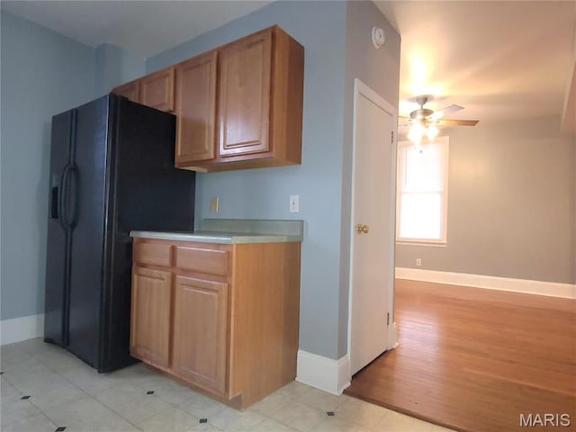 305 Macarthur St, Washington, MO 63090 - kitchen with black fridge, a ceiling fan, light countertops, and light wood-style flooring