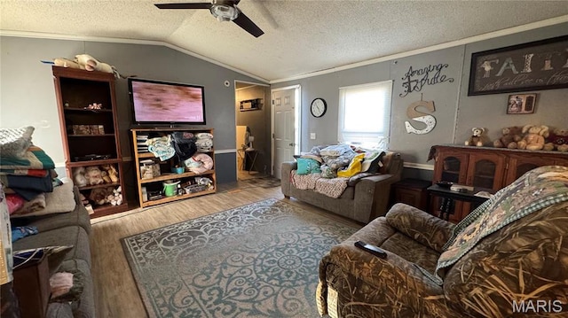 living area featuring ornamental molding, vaulted ceiling, wood finished floors, ceiling fan, and a textured ceiling