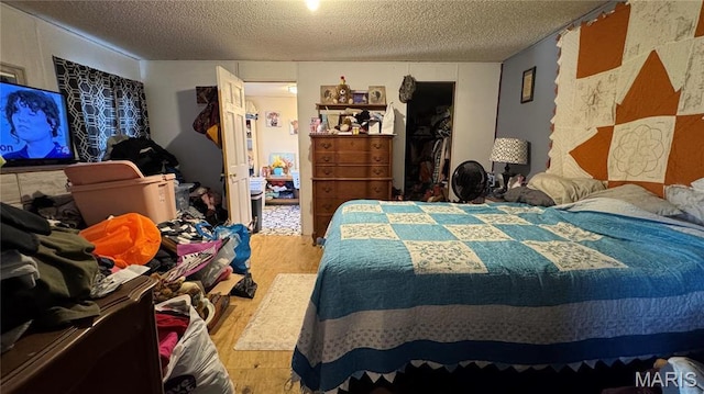 bedroom with a textured ceiling and wood finished floors