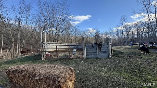 view of yard featuring fence and a wooded view