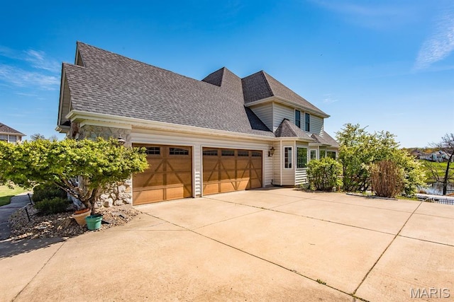 2314 Longest Dr, Wentzville, MO 63385 - view of front facade featuring a garage, roof with shingles, concrete driveway, and stone siding