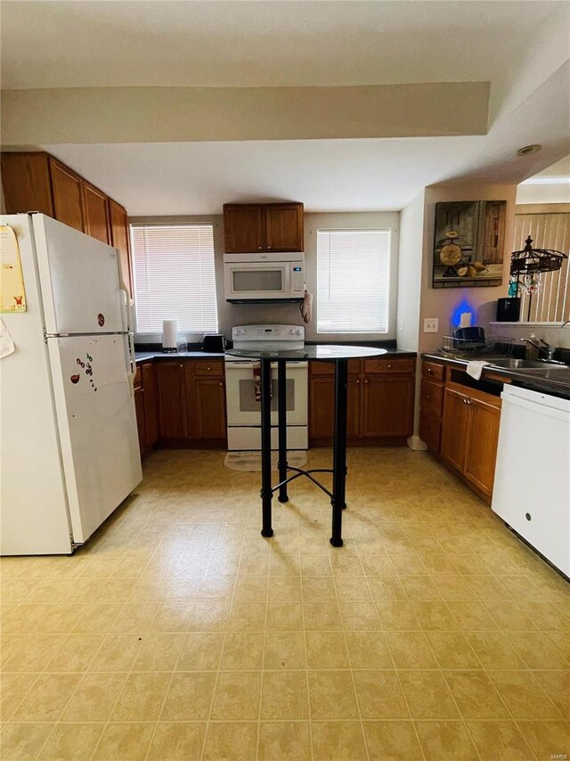 4934 W Florissant Ave, Saint Louis, MO 63115 - kitchen with white appliances, a sink, dark countertops, and brown cabinets