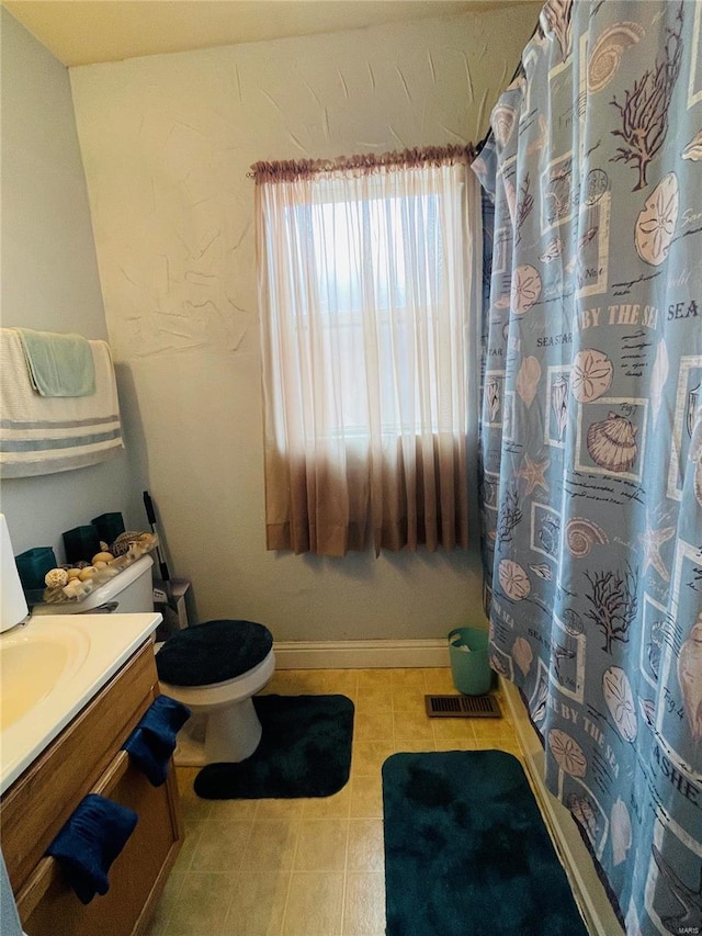 4934 W Florissant Ave, Saint Louis, MO 63115 - full bathroom featuring toilet, vanity, tile patterned flooring, and a shower with curtain