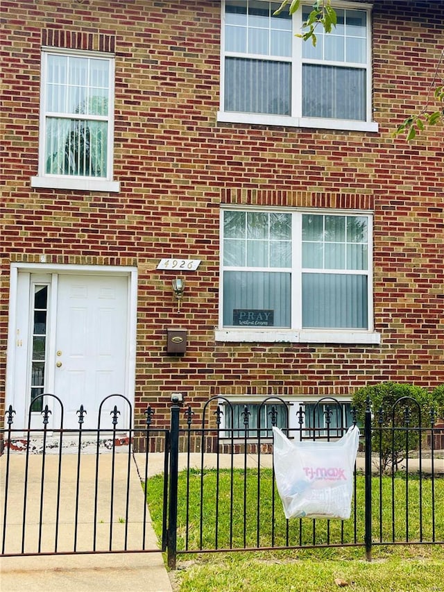 4926 W Florissant Ave, Saint Louis, MO 63115 - view of exterior entry with fence and brick siding