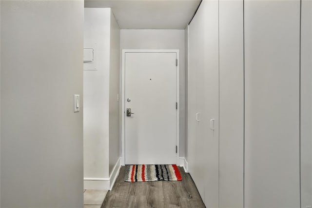 doorway featuring wood finished floors and baseboards